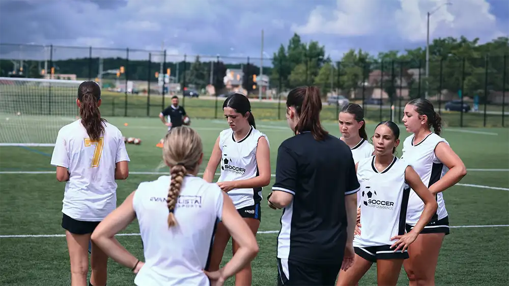 Coach giving a team talk to a group of young players