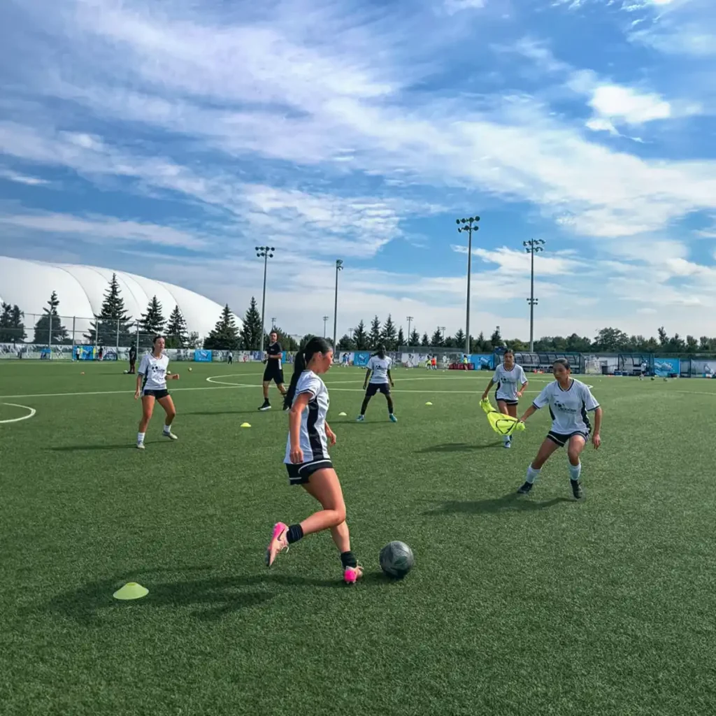 Player dribbling during a training drill at the camp