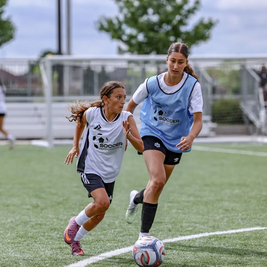 Player dribbling past a defender during a session